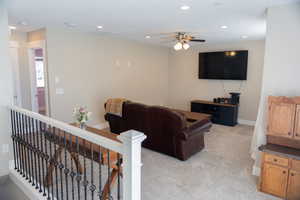 Living area featuring recessed lighting, light colored carpet, and a ceiling fan