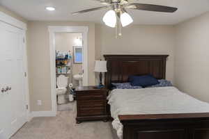 Bedroom with light colored carpet, ensuite bath, ceiling fan, and recessed lighting