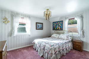Carpeted bedroom with wallpapered walls and baseboards