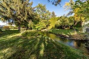 View of grassy yard with a water view