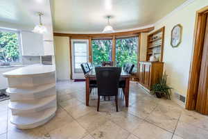 Dining space with crown molding and baseboards