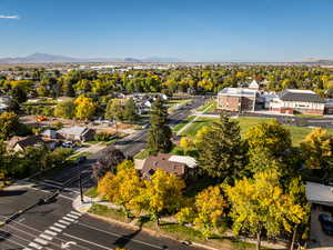 Aerial perspective of suburban area featuring mountains and a tree filled landscape