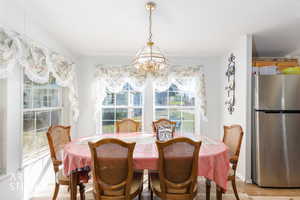 Dining room featuring light wood-style flooring and a chandelier