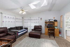 Carpeted living room featuring a skylight and ceiling fan