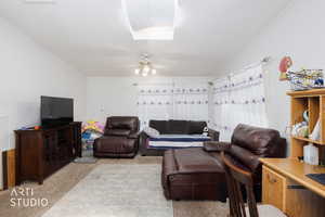 Living area featuring carpet and ceiling fan