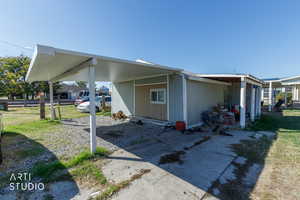 View of side of property with a yard, driveway, and an attached carport
