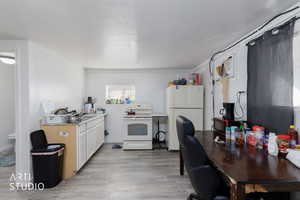 ADU Kitchen featuring white appliances, light wood-style flooring, white cabinetry, and light countertops