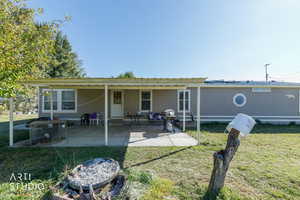 Rear view of house featuring a yard and a patio