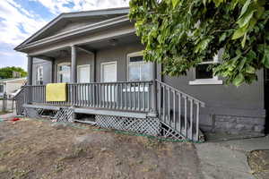 Rear view of property featuring brick siding and a porch