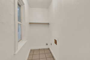 Washroom featuring light tile patterned floors and hookup for a washing machine