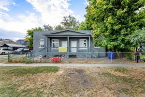 Bungalow featuring covered porch and a fenced front yard