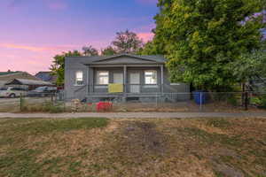 Bungalow featuring a porch and a fenced front yard