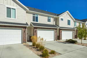 View of front of house with concrete driveway, an attached garage, and board and batten siding