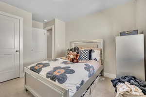 Bedroom with light colored carpet and baseboards