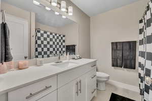 Bathroom with vanity, light tile patterned floors, and curtained shower