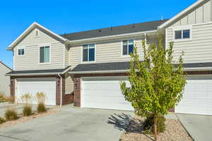 View of front of home with a shingled roof, board and batten siding, and concrete driveway
