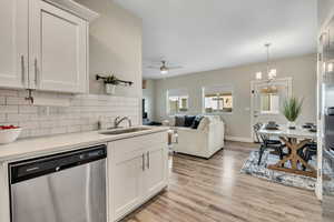 Kitchen featuring dishwasher, white cabinetry, and open floor plan