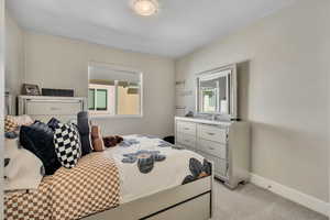 Bedroom featuring light colored carpet and baseboards