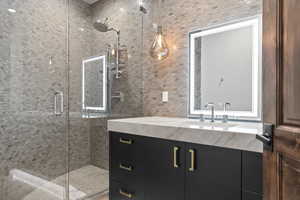 2nd Bedroom Bathroom featuring vanity, a stall shower, and tile walls