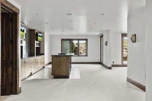 Basement Kitchen with a center island, light colored carpet, dark countertops, and recessed lighting