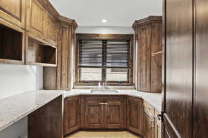 Laundry room featuring light stone countertops, recessed lighting, and light tile patterned flooring