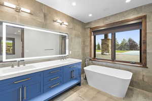 Bathroom featuring tile walls, double vanity, walkin Shower and a freestanding garden tub