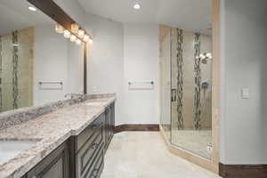 Bathroom featuring double vanity, a shower stall, and recessed lighting