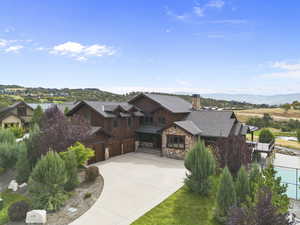 Rustic Mountain home with stone siding, Heated driveway, a chimney, board and batten siding, and a mountain view