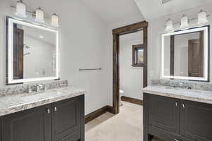 Bath featuring two vanities, a shower stall, and lofted ceiling