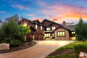 Craftsman inspired home with driveway, stone and cedar siding, a chimney, and 3 car garage