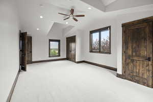 Huge bedroom featuring multiple windows, lofted ceiling, light carpet, a ceiling fan, and recessed lighting
