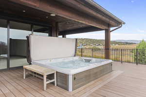 Wooden deck with an outdoor hot tub and a mountain view