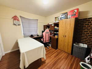 Office space with wood finished floors and a textured ceiling