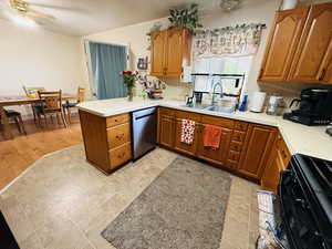 Kitchen featuring black range, light countertops, and brown cabinetry
