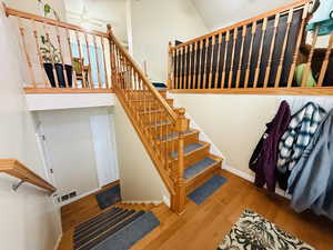 Stairs featuring a high ceiling, wood finished floors, and ceiling fan