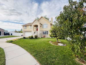 Bi-level home featuring concrete driveway, a garage, and brick siding