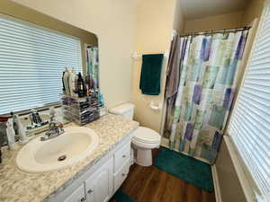 Full bathroom featuring vanity, dark wood-type flooring, and shower / bath combo