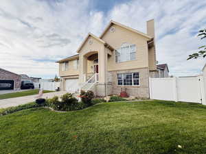 Bi-level home with brick siding, a chimney, driveway, and a garage