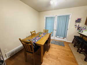 Dining area with light wood-style floors and french doors
