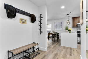 Kitchen with decorative light fixtures, brown cabinetry, light wood-type flooring, appliances with stainless steel finishes, and recessed lighting