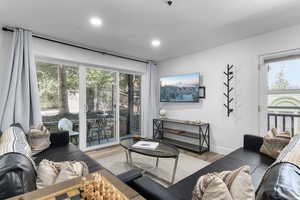 Living area with wood finished floors, healthy amount of natural light, and recessed lighting