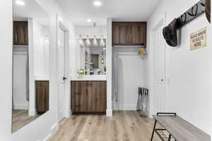 Bar area featuring dark brown cabinetry, light wood-type flooring, recessed lighting, and modern cabinets