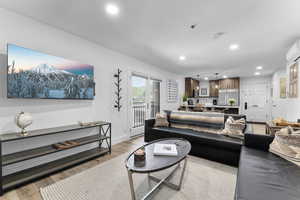 Living area featuring recessed lighting, light wood-type flooring, and a wall mounted air conditioner