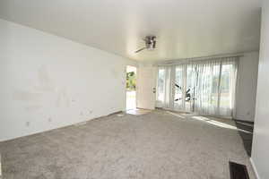 Spare room with carpet floors and a ceiling fan