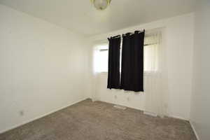 Unfurnished room with carpet floors and baseboards