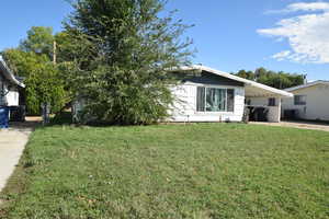 View of front facade with a front lawn, driveway, and an attached carport