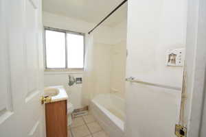 Full bath featuring light tile patterned flooring, vanity, and shower / bath combination with curtain