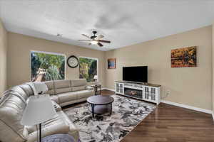 Living area with wood finished floors, a textured ceiling, and ceiling fan