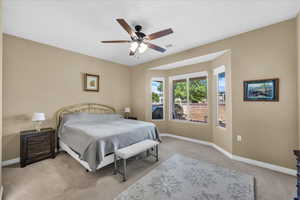 Bedroom featuring light colored carpet and ceiling fan