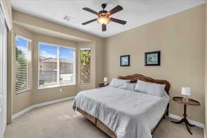 Bedroom featuring carpet floors, a textured ceiling, and ceiling fan